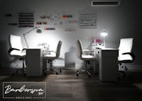 a nail salon with two white chairs and a lamp