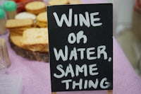 a sign that says wine or water, same thing